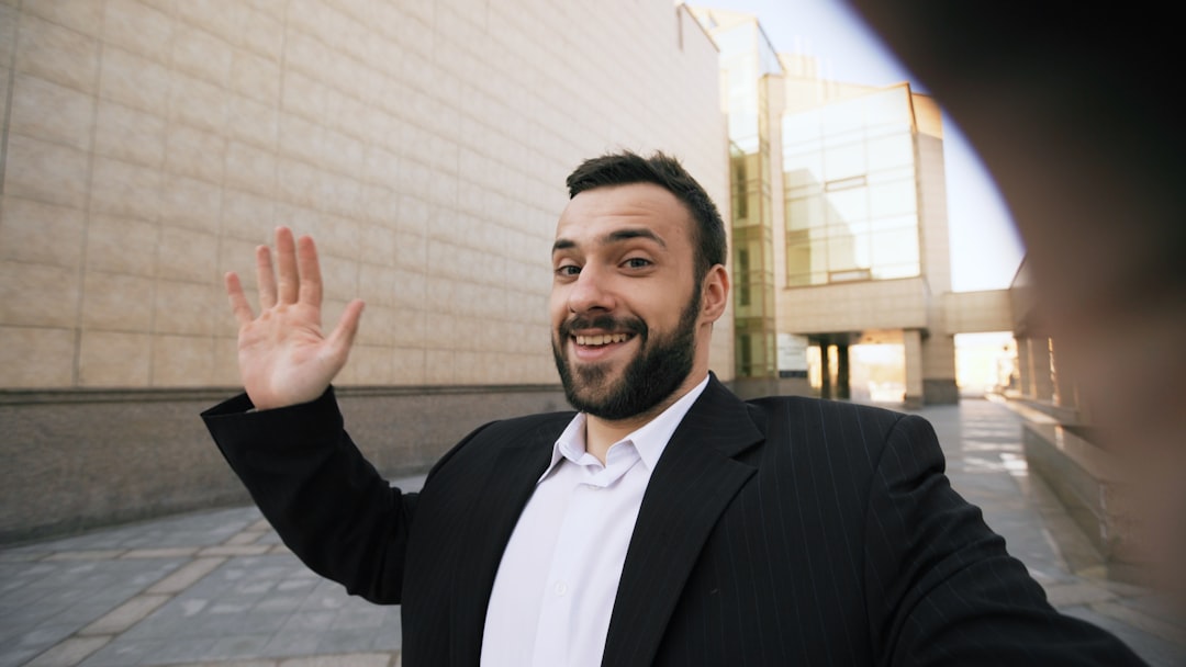 Young bearded businessman talking smartphone having online video chat business meeting