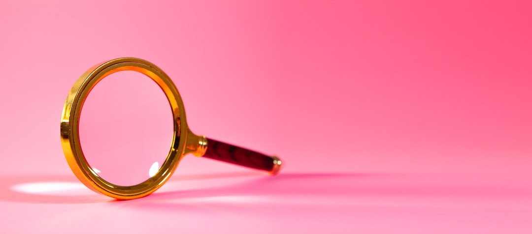 Magnifying glass on pink background.