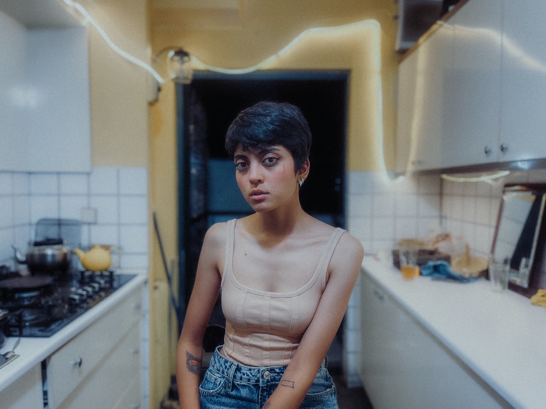 a woman standing in a kitchen next to a stove top oven