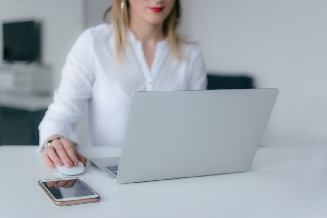 woman sitting and using MacBook Air and Apple Magic mouse